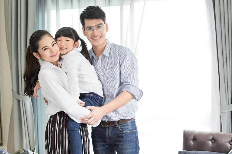 couple hugging their daughter